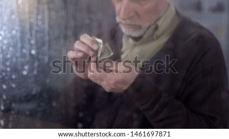 Poor retired man counting money in hand, economic crisis, financial problem