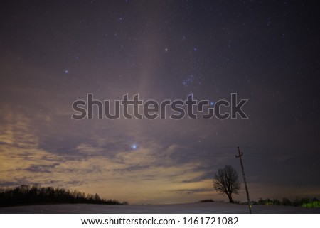 Photo of the night sky outside the city. In the background field and trees. Photo for screensaver and background