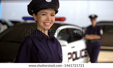 Beautiful patrolwoman smiling near police car, police academy advertisement Royalty-Free Stock Photo #1461721721