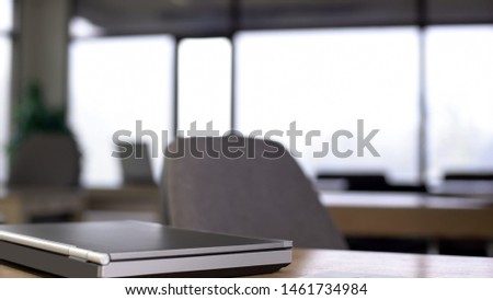 Empty office, laptop lying on table, end of working day, modern space interior