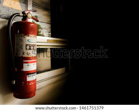 Red fire extinguisher on black background