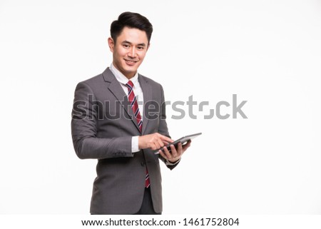 Close up shot of Asian businessman standing and using tablet computer isolated on white background, copy space on right side.