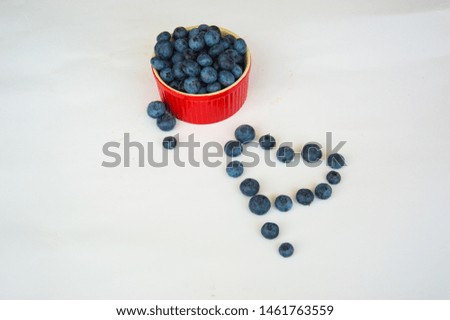red plate with blueberries on white background