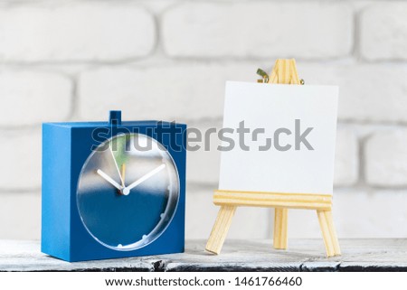 Blank mini canvas on easel on wooden table, copy space