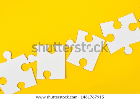 blank white big puzzles on yellow background, flat lay