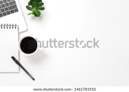 Flay lay, Top view office table desk with computer laptop, coffee cup, pen, green leaves and blank notepad with copy space background.