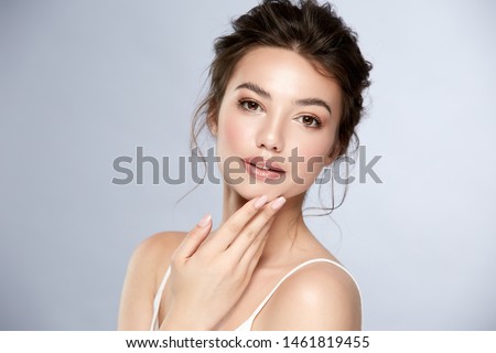 attractive brunette with shiny highlighters and glossy lips touching her chin, pretty woman with natural mua and perfect hairstyle Royalty-Free Stock Photo #1461819455