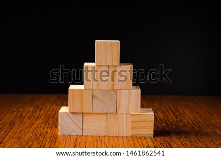 Wooden blocks stacked against black background