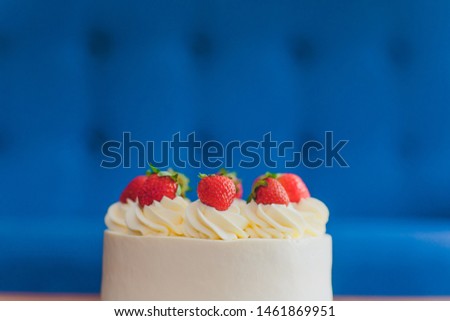 Sweet cake with strawberries on plate on wooden background.