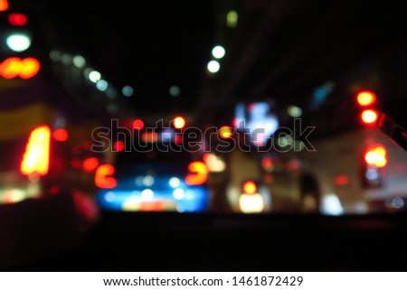 Blurred bokeh light of cars and vehicles on road in night time. View from front mirror of my car.