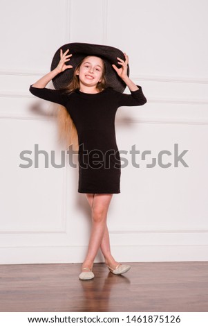 little fashion model in dress photo in photostudio backstage. A child of a girl of 8-9 years old is posing as an adult. Long hair. Modern children. Schoolgirl on a photo shoot.
