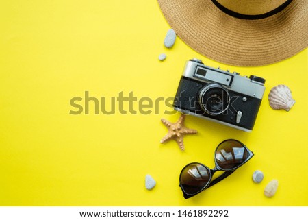 Vintage camera, hat, swimsuit, sunglasses on a yellow background. Summer concept. Flatlay, copyspase