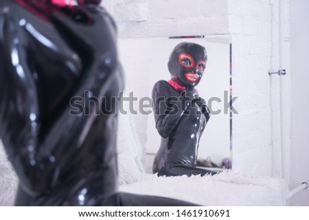 portrait of a beauty girl with big plastic anime head in latex mask