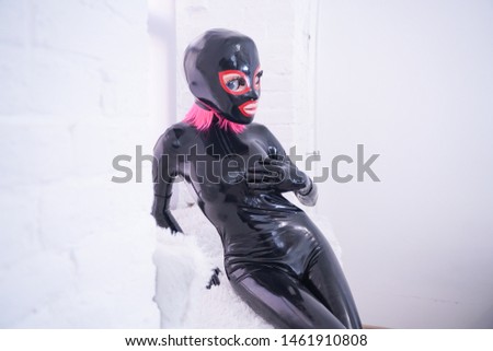 portrait of a beauty girl with big plastic anime head in latex mask