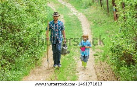 It is my life. happy earth day. Family tree nursering. father and son in cowboy hat on ranch. Eco farm. watering can, pot and shovel. Garden equipment. small boy child help father in farming.