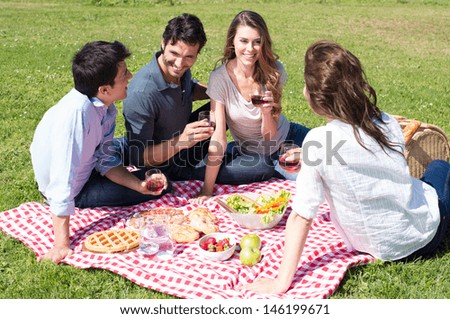 Group Of Happy Young Friends On Vacation Enjoying Wine At Picnic
