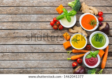 Healthy food, clean eating concept. Variety of colorful seasonal fall vegetables creamy soups with ingredients. Pumpkin, broccoli, carrot, beetroot, potato, tomato spinach. Flat lay, copy space