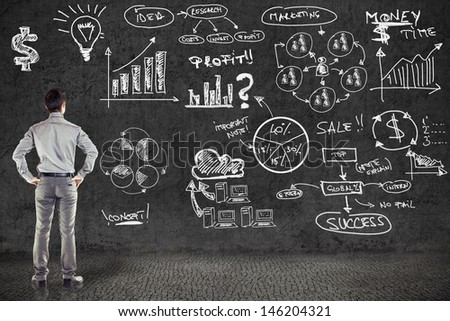 businessman in suit and business plan on grunge wall