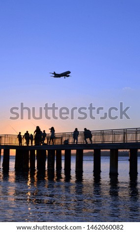 people and airplane taking landscape photo at sunset