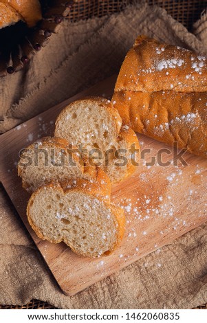 French bread, sprinkled with icing sugar on a wooden chopping board, classic colors, breakfast ideas and snacks
