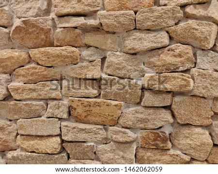 Rough free form brick wall textured background in warm tone