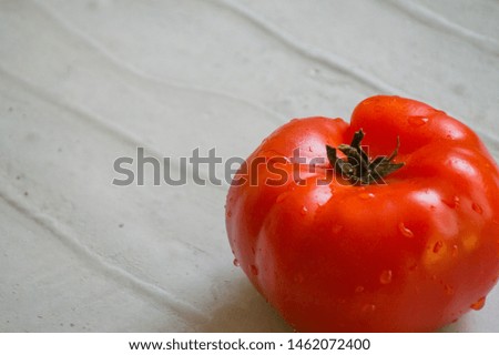 
Red big, juicy tomato on a gray background