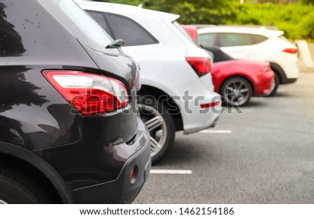 Closeup of rear, back side of dark brown car with other cars parking in outdoor parking area in sunny day. The mean of simply transportation in modern world. Royalty-Free Stock Photo #1462154186