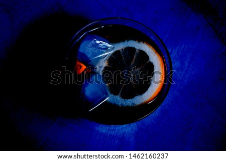 colorful picture with glass of water and peaces of lemon and ice 