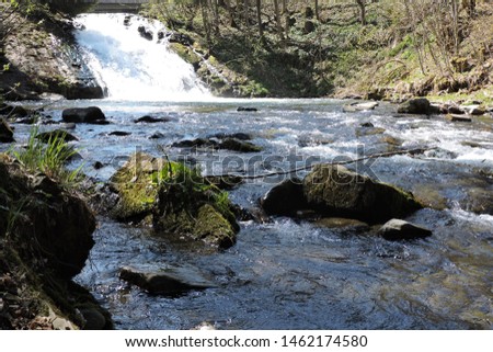 A beautiful view of a waterfall, some rocks in a stream in the Tatra Mountains in Poland