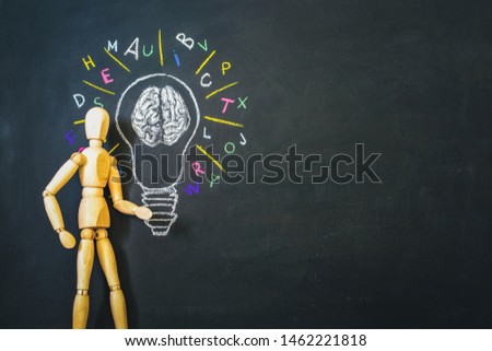 bulb with human brain and letters on chalkboard and wooden man