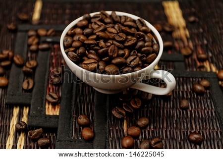 Coffee beans in ceramic white coffee cup