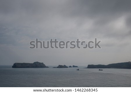 photo of a landscape with islands and fishing boats approaching the lighthouse