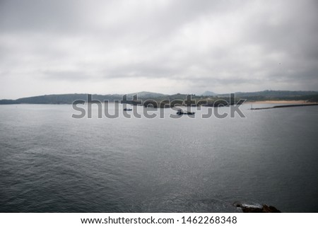 photo of a landscape with islands and fishing boats approaching the lighthouse