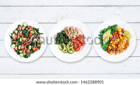 Assortment of various healthy keto paleo meals on white plate. Wood background. Top view. Isolated. Copy space. 