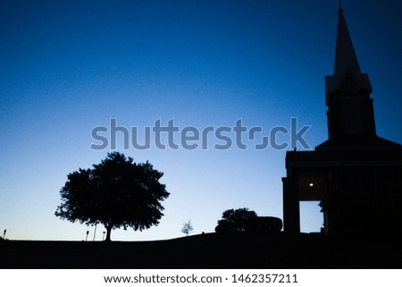 Blue sky and silhouette of church and tree in the morning before sunrise