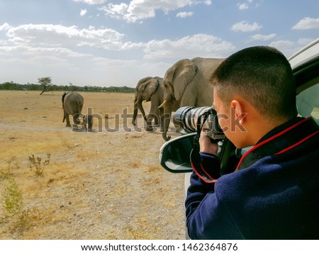 Tourist photographer on safari in Namibia Royalty-Free Stock Photo #1462364876