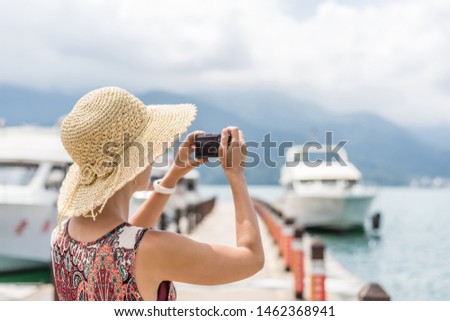 traveling Asian woman with hat take a pictures at Sun Moon Lake, Taiwan