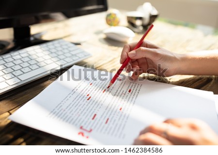 Close-up Of A Person's Hand Marking Error With Red Marker On Document Royalty-Free Stock Photo #1462384586