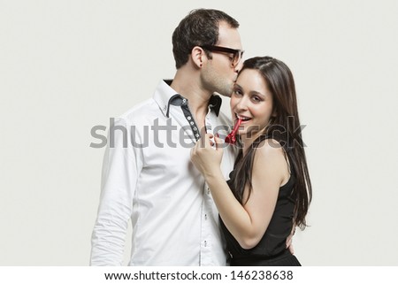 Young couple with party puffer against gray background