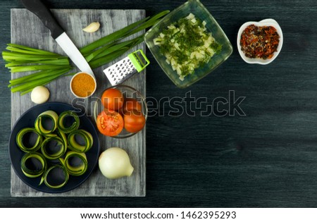 Zucchini in the background. Fried young sliced courgettes in a pan on a dark background. The view from the top. Copy space
