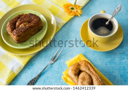 Yellow morning scene with cup of coffee and typical Dutch cinnamon roll cake called Zeeuwse Bolus Royalty-Free Stock Photo #1462412339