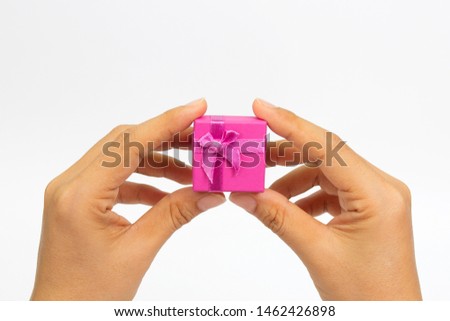 Women's hands holding small gift box on white background