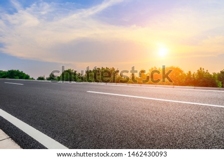 Beautiful rural asphalt road scenery at sunset Royalty-Free Stock Photo #1462430093
