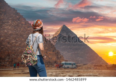 Woman tourist walks on the background of the pyramids in Giza. Egypt Royalty-Free Stock Photo #1462485899