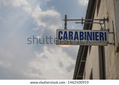 An old illuminated sign board for Carabinieri, a part of an italian police force. Board is hanging from a wall in a house