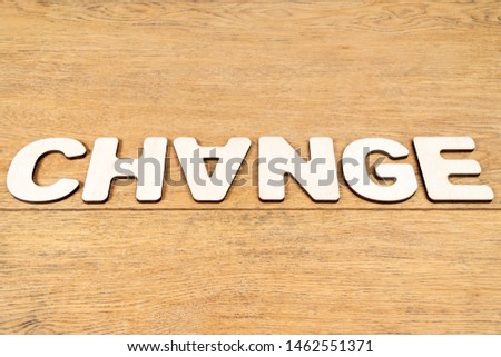Word - change, laid out in wooden letters on an old wooden table, with inverted A