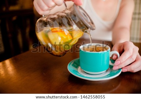 Female hands holding tea pot  hot green tea cup beverage, drinks citrus . Horizontal several objects copyspace