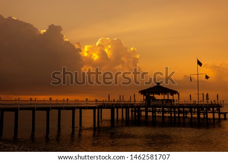 Beautiful early morning sunrise landscape of empty beach, sea water and great amazing cloudy dramatic sunrise with first sunlight rays, beams through huge white clouds. Horizontal natural background.
