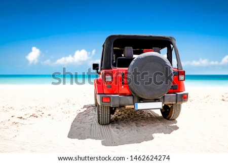 Red summer car on beach and free space for your decoration. Blue sky and ocean landscape. 