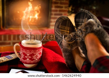 Chilling beside the fireplace with a mug of coffee. Royalty-Free Stock Photo #1462624940